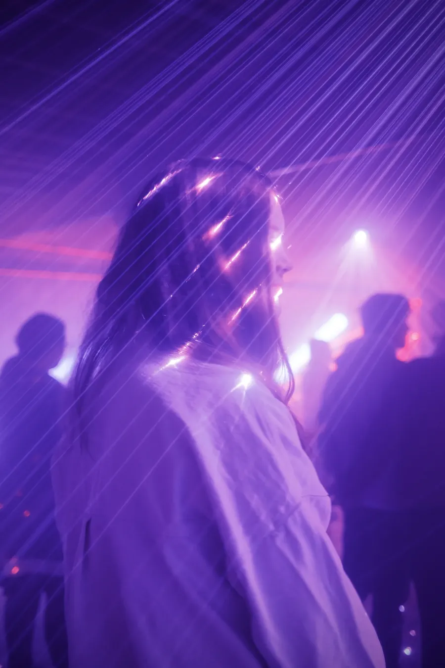A figure lit by purple stage light.