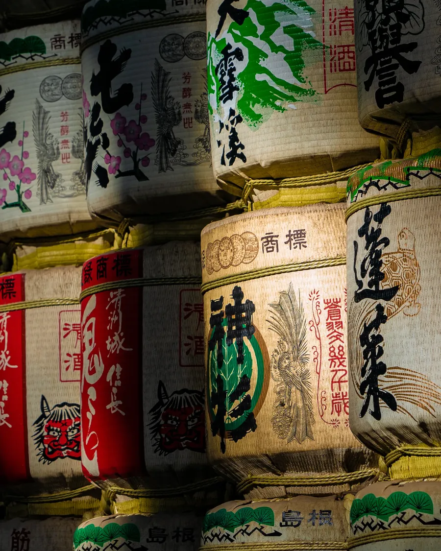 Painted sake barrels stacked in a wall.