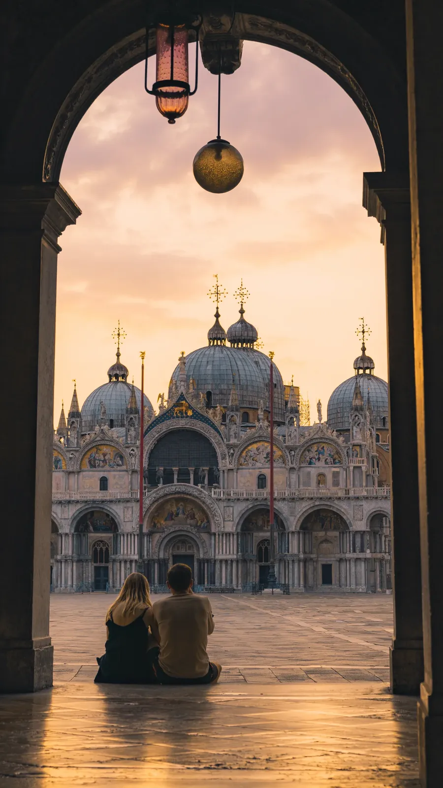 A basilica framed by an arch at dawn.